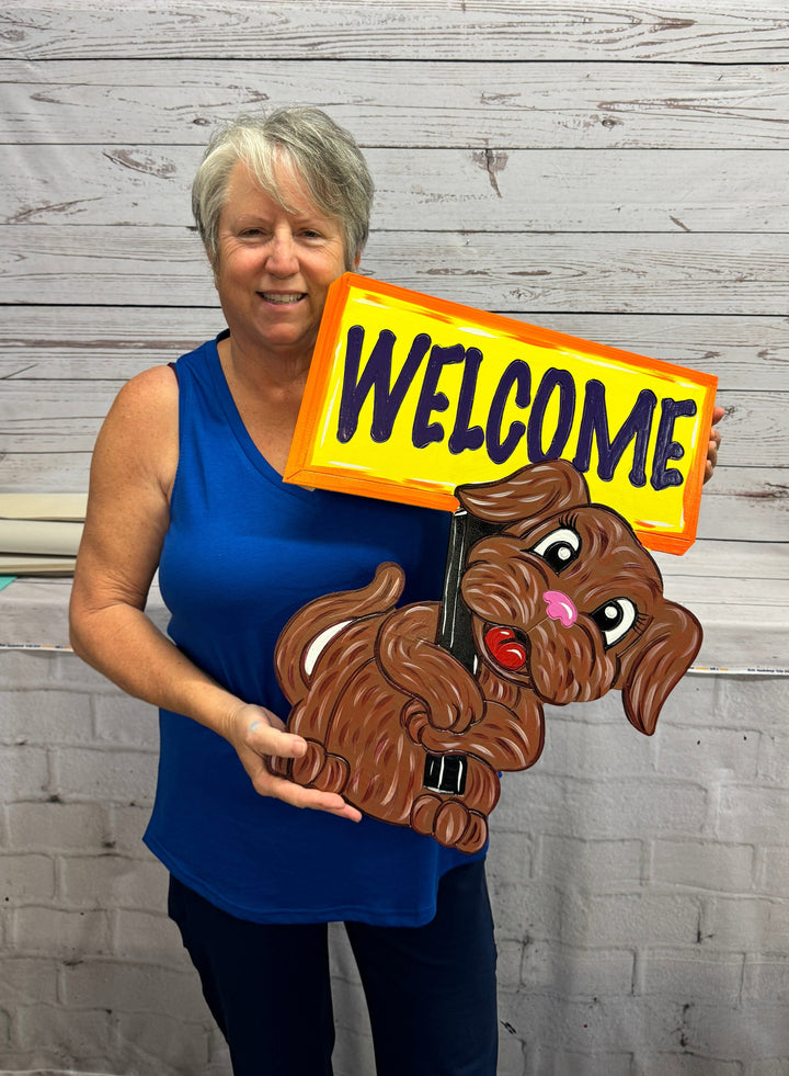 Dog Holding a Hand-Made Welcome Sign created  by Mary Amick | Yard Art Decor and More.