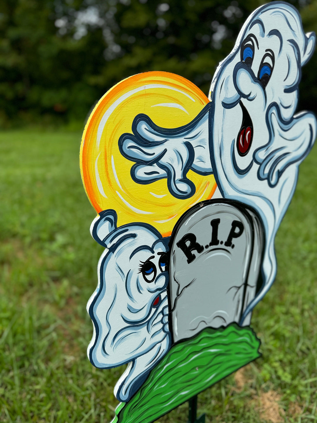 Two Halloween Ghosts Peeking over RIP Tombstone