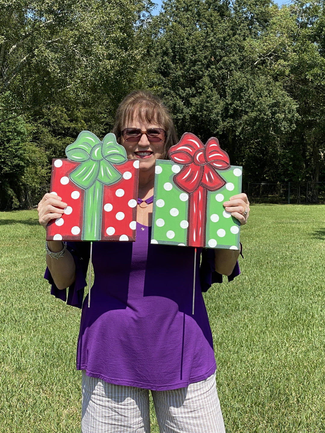 woman holding painted yard art present with veritcle bow