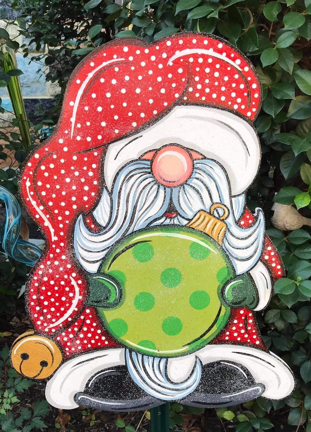 glitter santa gnome holding ornement with polka dot santa hat painted yard art design