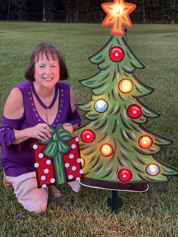 light up tree and woman holding yard art present painted yard art design